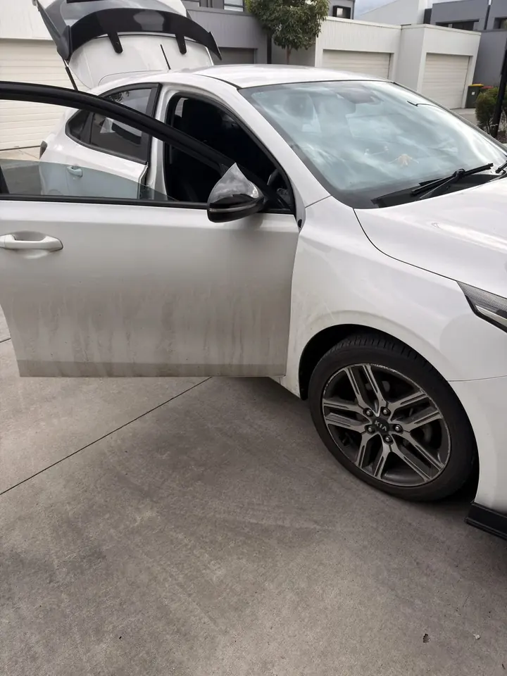 Kia Cerato before: mud streaks down the white door